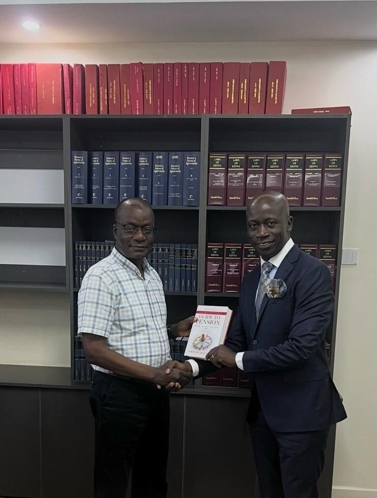 A copy of The Practitioner’s Guide to Pension Administration being presented in an office with shelves of law books.