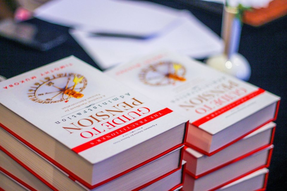 Copies of the book stacked on a table at a launch event